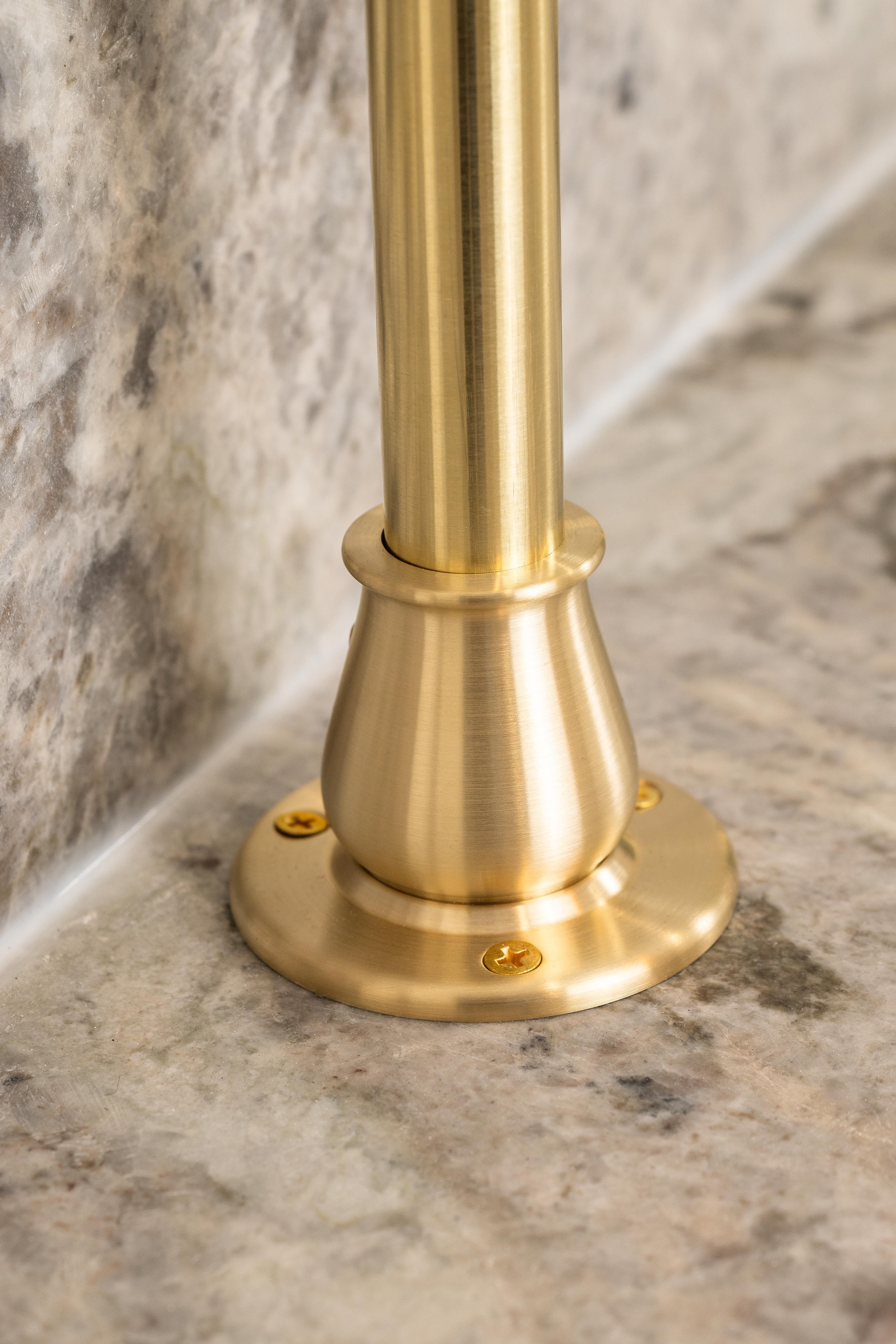 A mounting flange for a bistro shelving unit made from real brass attached to a countertop.