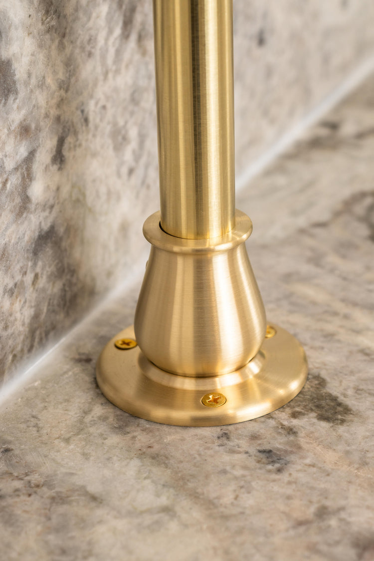 A mounting flange for a bistro shelving unit made from real brass attached to a countertop.